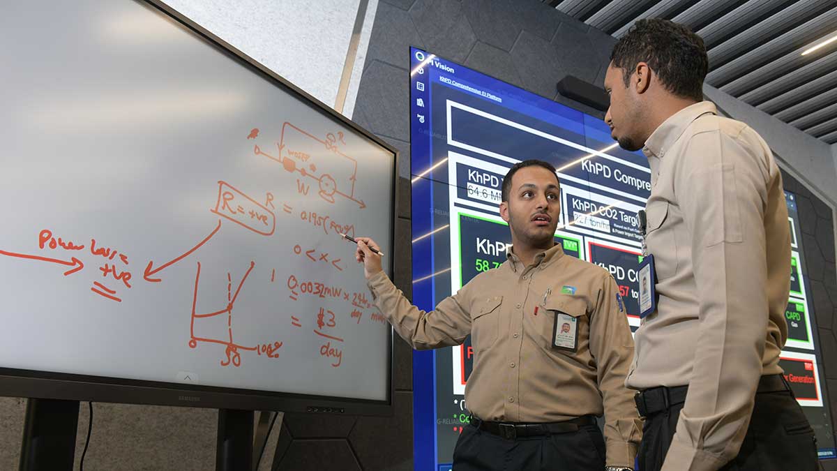 Aramco energy coordinator Abdullah Al-Zahrani discusses potential solutions with a colleague in Khurais