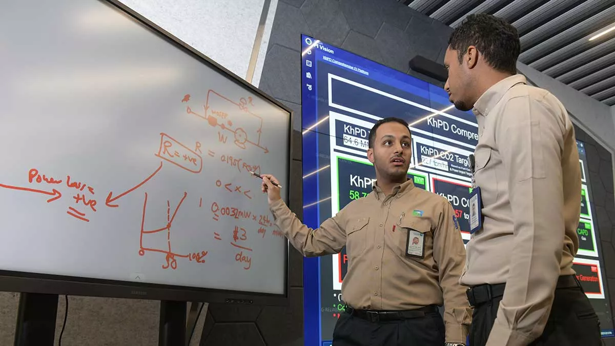 Aramco energy coordinator Abdullah Al-Zahrani discusses potential solutions with a colleague in Khurais
