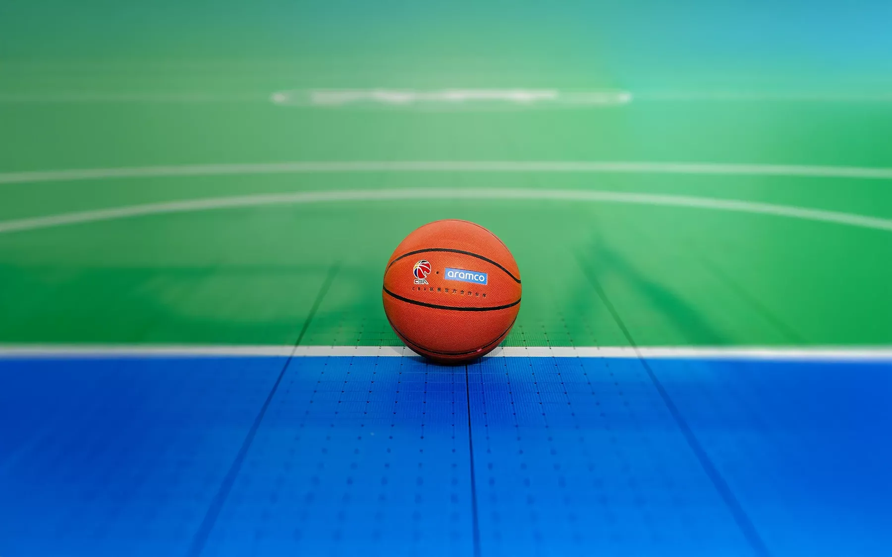 CBA ball laying on the ground centered on the Aramco Court